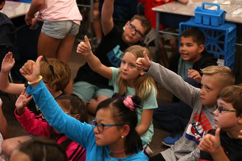 Engleman Elementary students giving "thumbs up" in a classroom.
