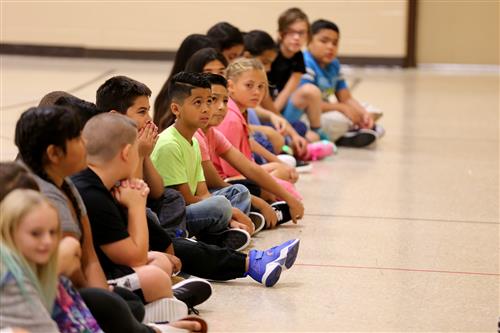 Jefferson Elementary students sitting and listening in the gym. 