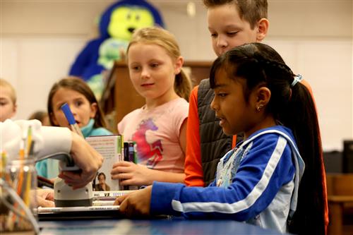 Seedling Mile students checking out library books at the media center