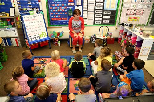 Stolley Park kindergarten students sitting on the floor listening to teacher