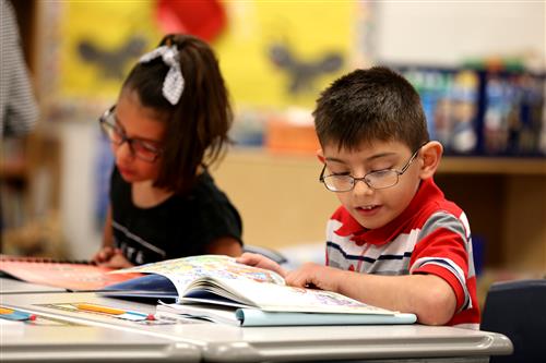 Two Wasmer students reading books at their desks