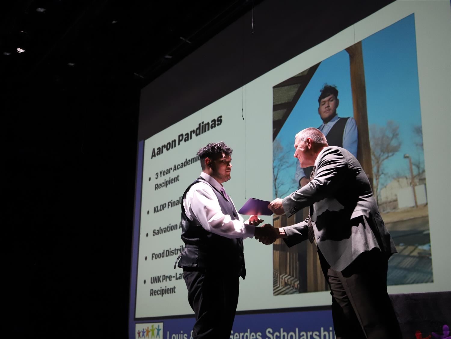 GIPS Superintendent, Mr. Fisher, shaking the hand of Aaron Pardinas on stage for Academic Honors Night.