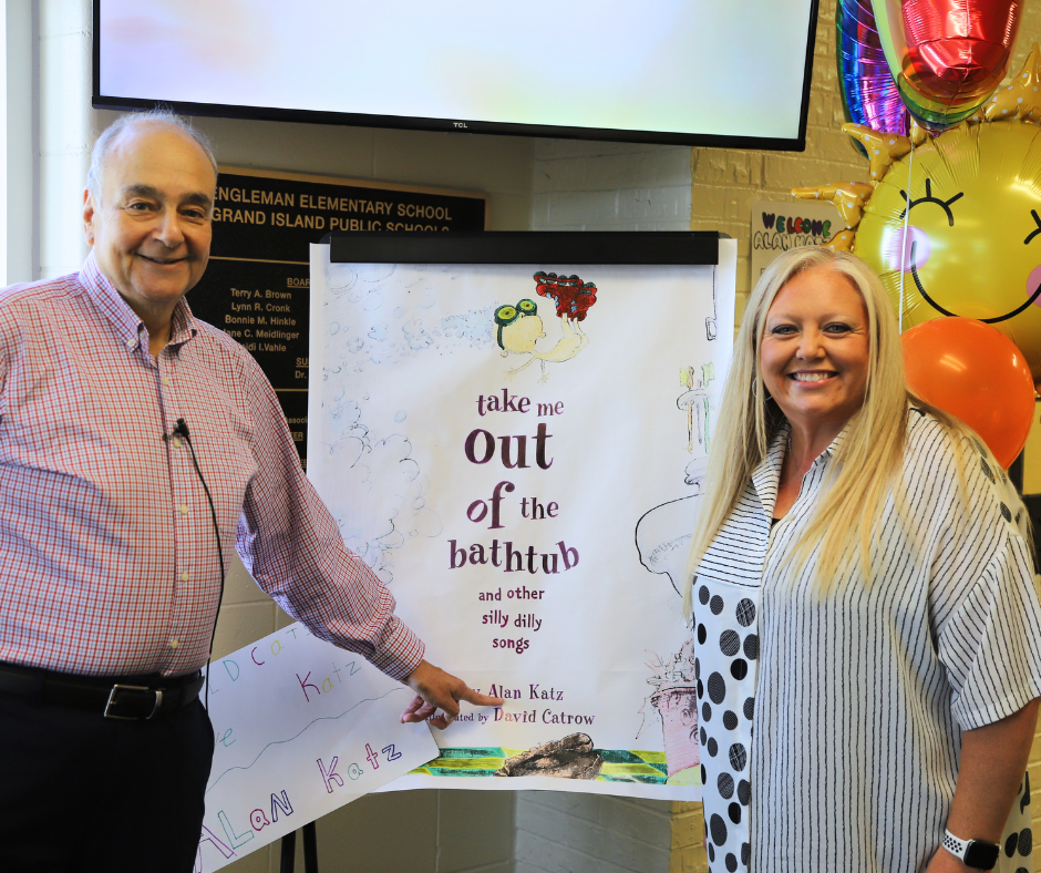 Alan Katz & Jennifer Shafer-Ehlers smiling next to the "Welcome" poster at Engleman.