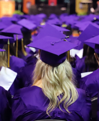 Behind photo of sitting GISH Graduates in regalia at the 2024 graduation ceremony. 