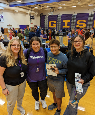  Four GISH Students smiling at the college fair holding their college packets