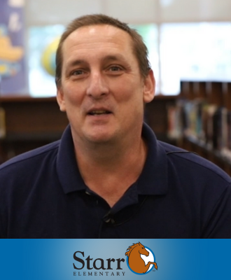  Roger Fisher smiling in the Starr Elementary library with the Starr logo at the bottom.