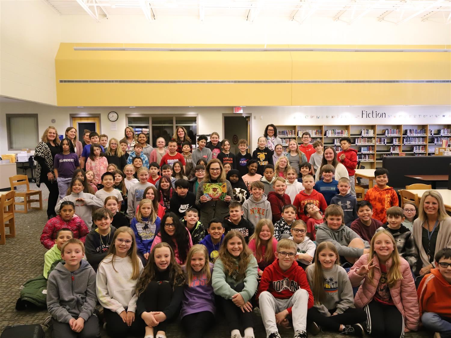 Engleman Elementary 4th Graders and teachers smiling with Nebraska First Lady, Suzanne Pillen, in the Engelman media center.