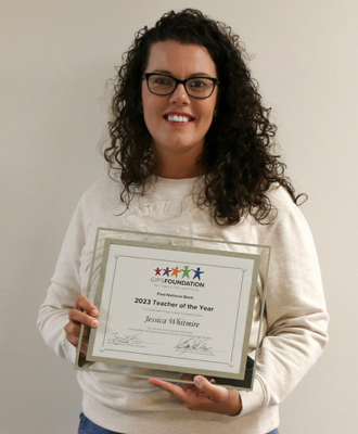  Jessica Whitmire smiling and holding her High School Teacher of the Year plaque